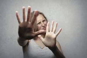 Nervous woman with hands in front of face