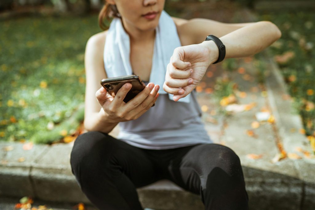 Woman checking fitness app and smart watch