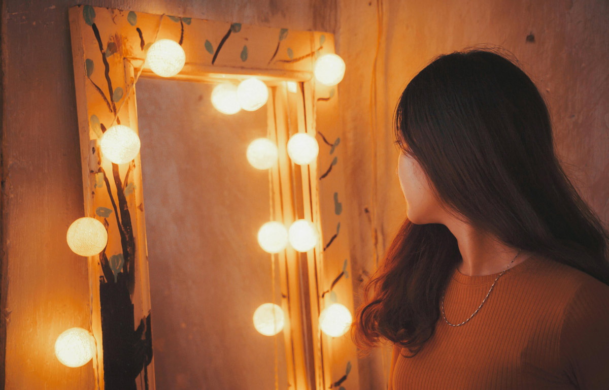 Woman facing vanity mirror.