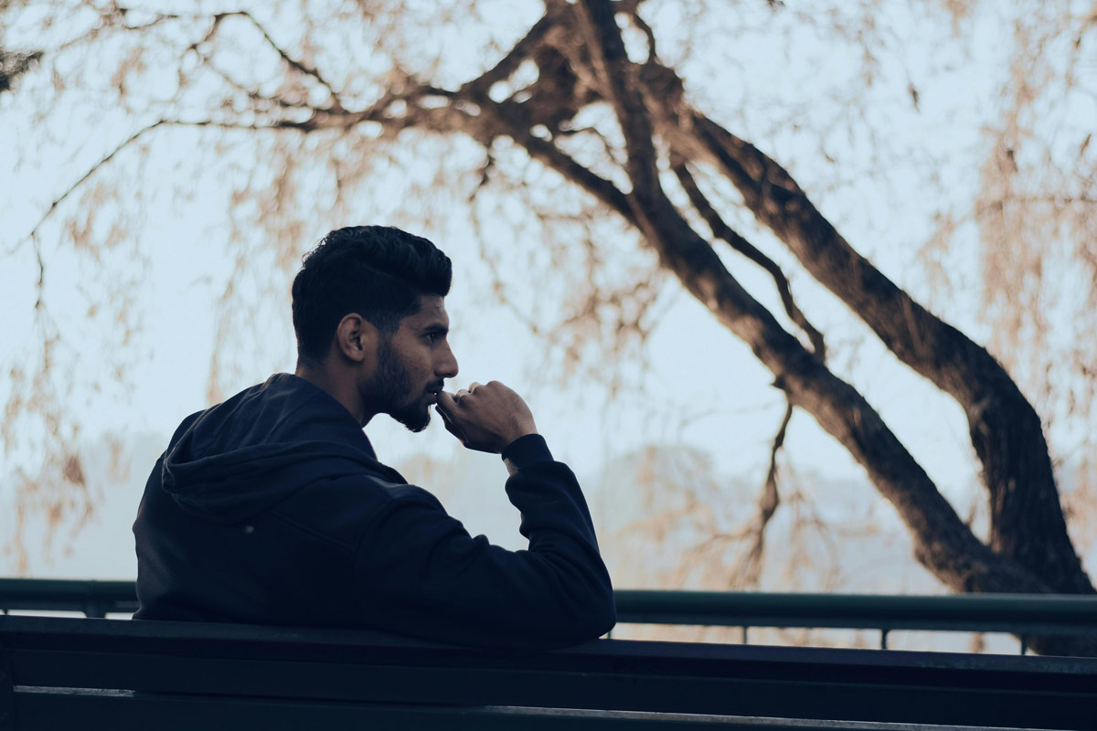 Man on park bench looking throughtful