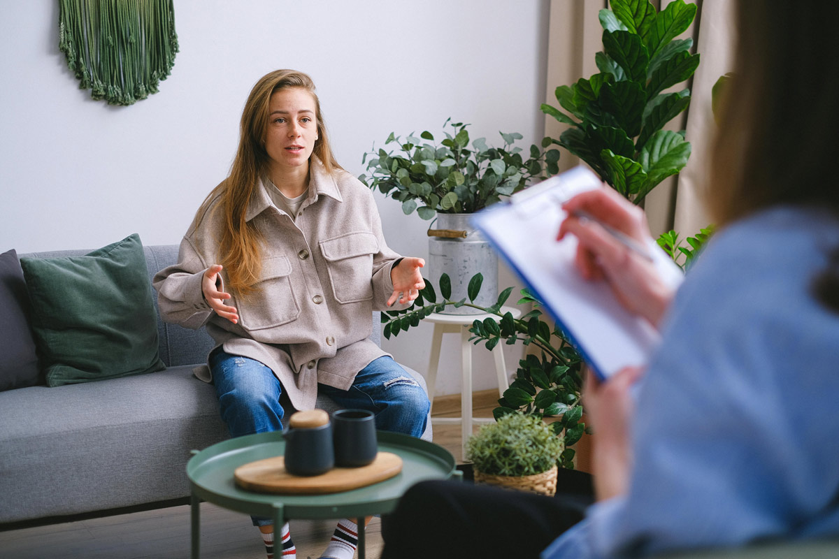 Young woman sitting on couch in therapy session.