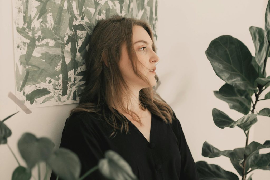 Thoughtful woman standing among plants