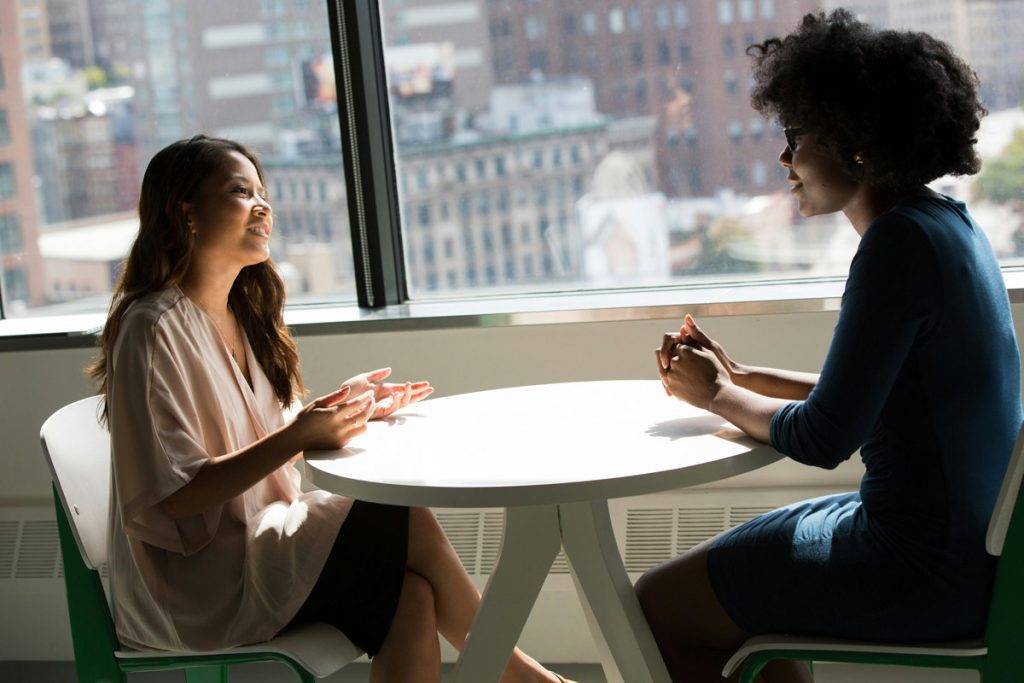 Two friends talking at a table